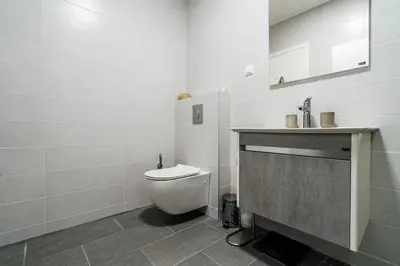 a white bathroom with a toilet and a sink at Olive Tree Apartments by In Property in Becici