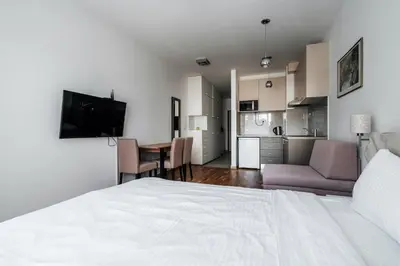 a bedroom with a bed and a living room at Central studio by In Property in Budva