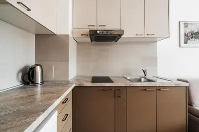 a kitchen with white cabinets and a sink at Central studio by In Property in Budva