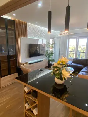 a living room with a table with flowers on it at Rent a apartment Podgorica in Podgorica