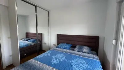 a bedroom with two beds and a mirror at Apartman Podgorica in Podgorica