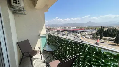 a balcony with chairs and a view of a city at Apartman Podgorica in Podgorica
