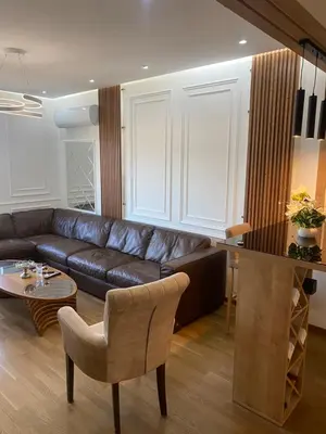 a living room with a leather couch and a table at Apartman Podgorica in Podgorica