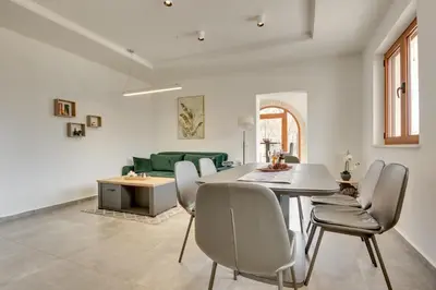 a living room with a table and a green couch at Sutorman 1 Villa D&B in Zupci
