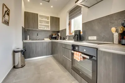 a kitchen with gray cabinets and a stove top oven at Sutorman 1 Villa D&B in Zupci
