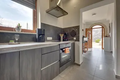 a kitchen with gray cabinets and a counter top at Sutorman 1 Villa D&B in Zupci