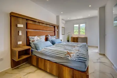 a bedroom with a large wooden bed with blue pillows at Jana in Utjeha