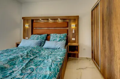 a bedroom with a bed with a wooden headboard at Jana in Utjeha