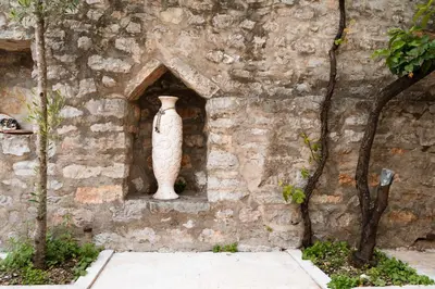 a vase on the side of a stone wall at Historic Seafront Family Villa in Rafailovici