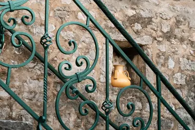 a green gate with a vase on it at Historic Seafront Family Villa in Rafailovici