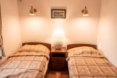 two beds in a room with a lamp on a night stand at Historic Seafront Family Villa in Rafailovici
