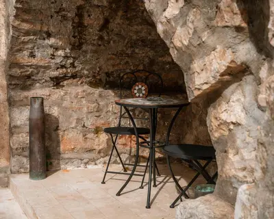 a table and two chairs in a stone room at Historic Seafront Family Villa in Rafailovici