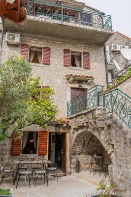 a building with tables and chairs in front of it at Historic Seafront Family Villa in Rafailovici