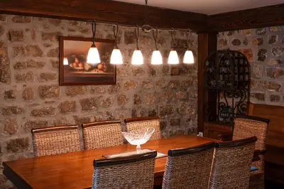 a dining room with a wooden table and chairs at Historic Seafront Family Villa in Rafailovici