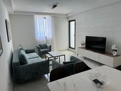 a living room with couches and a flat screen tv at Beach apartment Sveti Stefan in Sveti Stefan