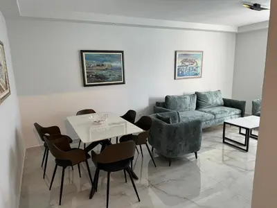 a living room with a couch and a table and chairs at Beach apartment Sveti Stefan in Sveti Stefan