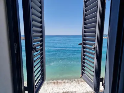 a window view of the ocean from a beach at Beach apartment Sveti Stefan in Sveti Stefan