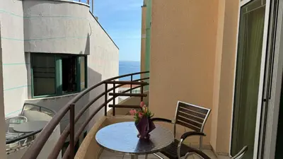 a balcony with a table with a vase of flowers on it at Sea La Vie Apartments in Ulcinj