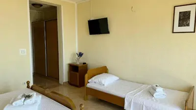 a room with two beds and a tv on the wall at Sea La Vie Apartments in Ulcinj