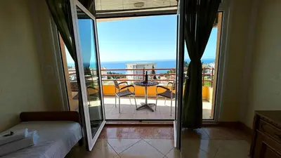 a bedroom with a balcony with a view of the ocean at Sea La Vie Apartments in Ulcinj