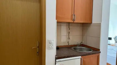 a small kitchen with a sink and wooden cabinets at Sea La Vie Apartments in Ulcinj