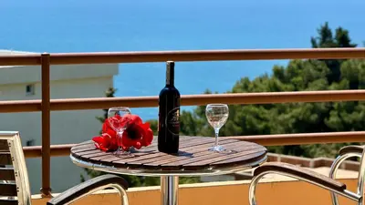 a table with a bottle of wine and two glasses at Sea La Vie Apartments in Ulcinj