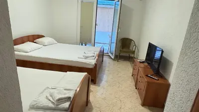 a bedroom with two beds and a tv and a dresser at Sea La Vie Apartments in Ulcinj