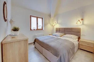 a bedroom with a large bed and a table at Sutorman 2 Villa D&B in Zupci