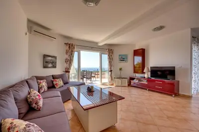 a living room with a couch and a table at Sun & Sea in Utjeha
