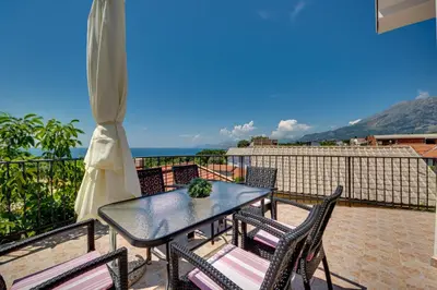 a table and chairs on a balcony with a view of the ocean at Sun & Sea in Utjeha