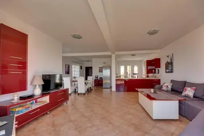 a living room with a couch and a tv at Sun & Sea in Utjeha