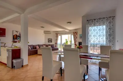 a kitchen and living room with a table and chairs at Sun & Sea in Utjeha