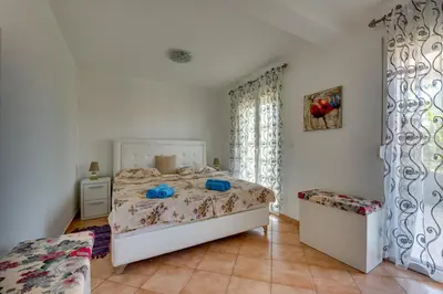a bedroom with a white bed and a window at Sun & Sea in Utjeha