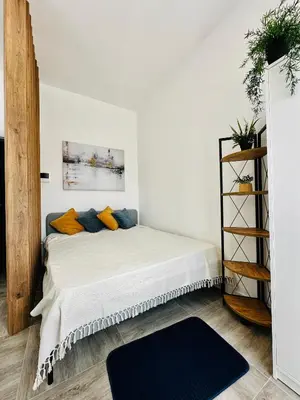 a bedroom with a bed with orange and blue pillows at Apartment for you in Bar