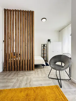 a bedroom with a sliding door with a chair and a bed at Apartment for you in Bar