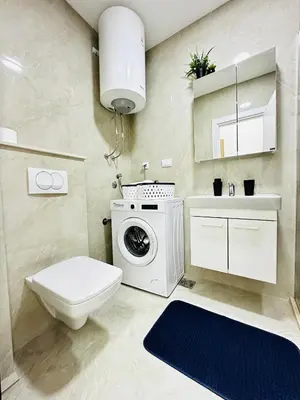 a bathroom with a toilet and a washing machine at Apartment for you in Bar