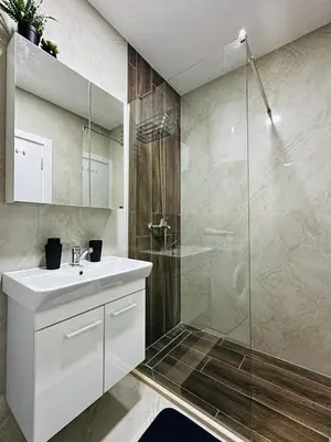 a bathroom with a white sink and a shower at Apartment for you in Bar