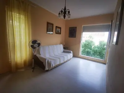 a living room with a white couch and a window at Villa Anlave in Sveti Stefan
