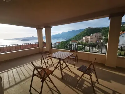 a table and chairs on a balcony with a view at Villa Anlave in Sveti Stefan