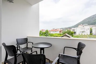 a room with chairs and a table and a window at Apartments Milivojevic in Bar