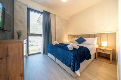 a bedroom with a bed and a large window at Invictus Hotel in Budva