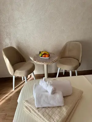 a bed with two chairs and a table with a bowl of fruit at Etno Selo Grabovicka Jutra in Cetinje