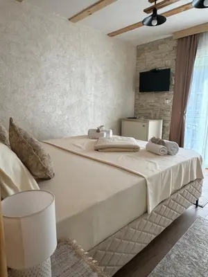 a bedroom with a large bed with a tv on the wall at Etno Selo Grabovicka Jutra in Cetinje