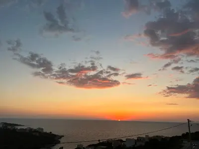 a sunset over the ocean with the sun in the sky at Villa Galatea in Utjeha