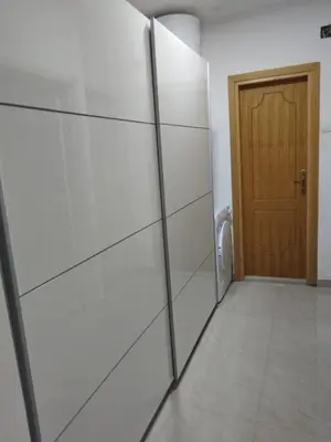 a bathroom with white walls and a wooden door at D&D Apartman in Bar