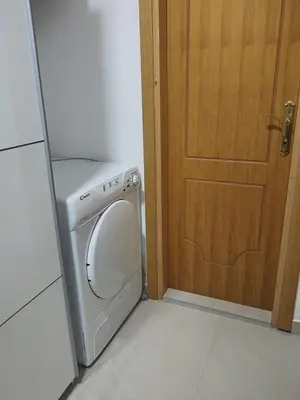 a washer and dryer sitting next to a door at D&D Apartman in Bar