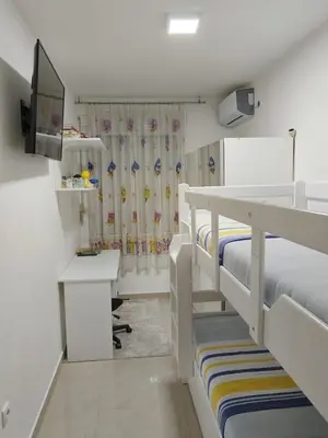 a room with two bunk beds with a desk and a computer at D&D Apartman in Bar