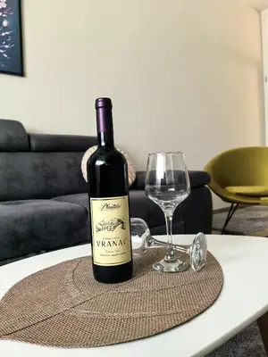 a bottle of wine sitting on a table with a glass at Sunny Hill - Parking - Fenced Garden - Luxury Loft in Kotor