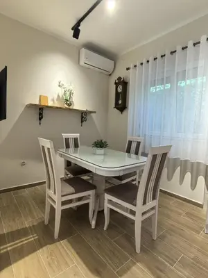 a dining room with a white table and chairs at Sunny Hill - Parking - Fenced Garden - Luxury Loft in Kotor