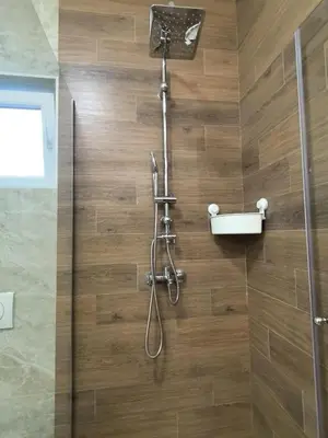 a shower with a shower head on a wooden wall at Sunny Hill - Parking - Fenced Garden - Luxury Loft in Kotor